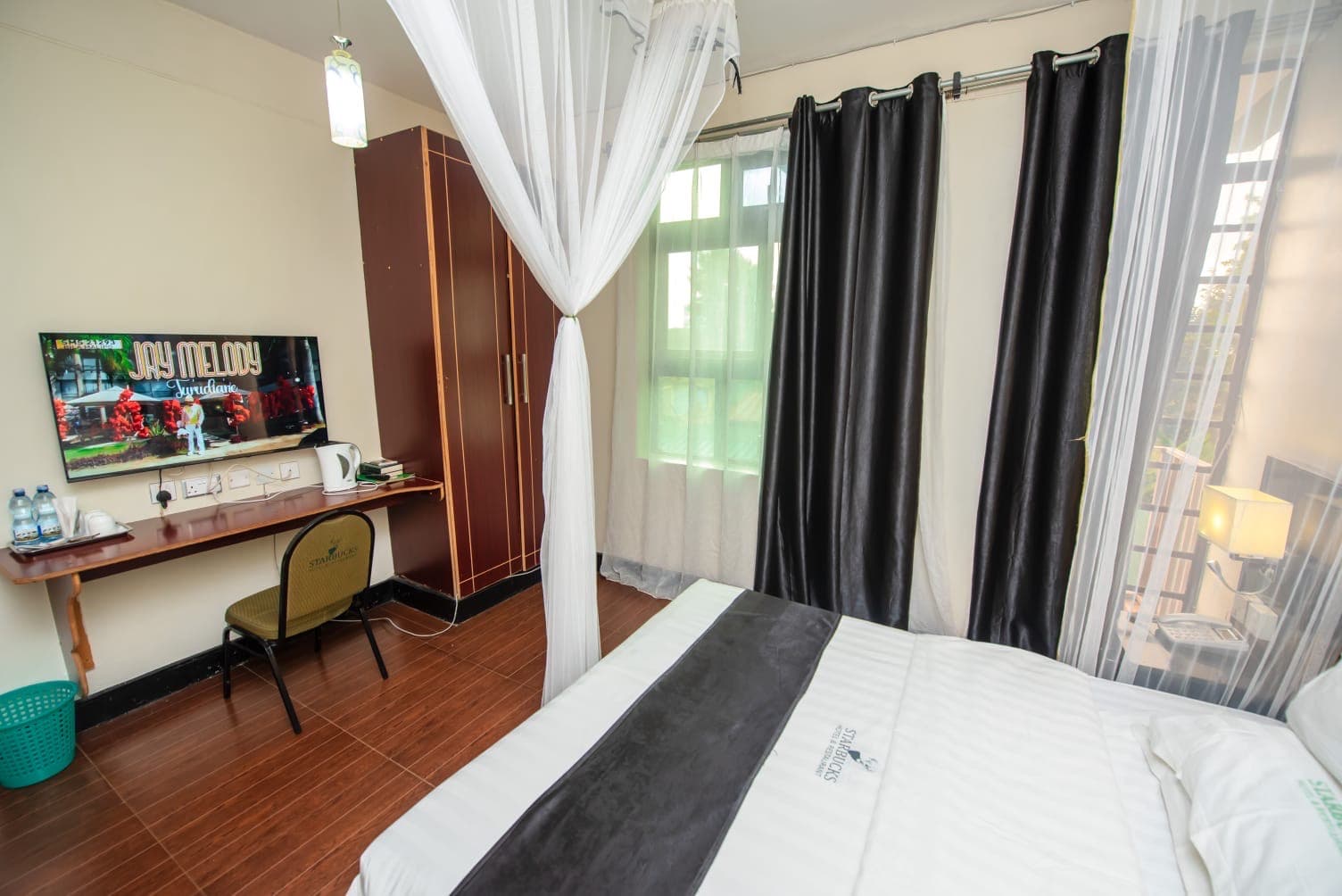 A work desk and television in a room at The Starbucks Hotel, Eldoret